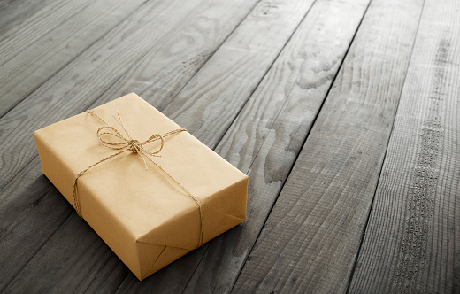 wrapped and tied parcel on wood background