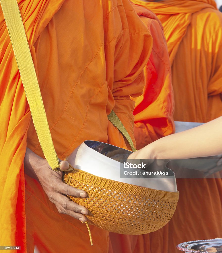 Colocar ofertas de alimento em um monge budista Tigela de Esmola - Foto de stock de Adulto royalty-free