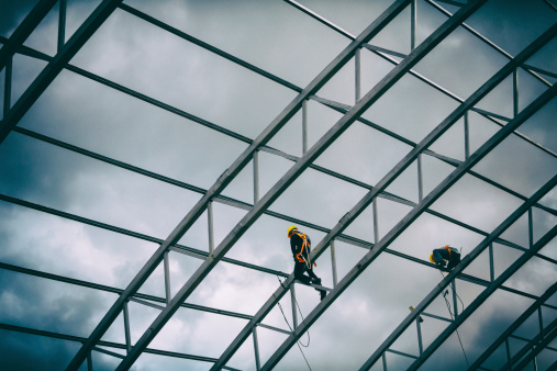 Steel frame construction workers with safety harnesses