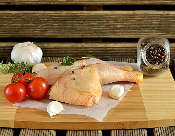 istock Fresh chicken legs with pepper on wooden table 489482851