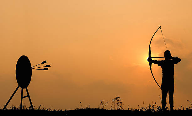 Silhouette archery shoots a bow at the target.