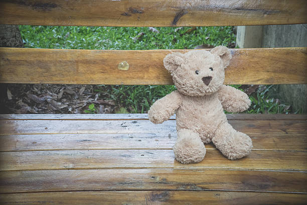 istock teddybear relaxing in a bench in the park 489483784