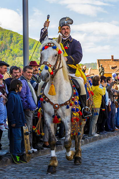 Brasov, Romania - April 27, 2014: Unidentified senior rider of Dorobanti Junii horsemen group greets the audience during the traditional parade of the Brasov Junii on April 27, 2014 in Brasov, Romania. 