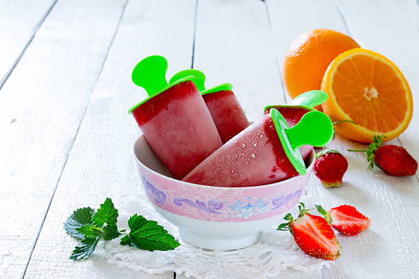 istock Strawberry ice cream popsicle orange on a white table 489485158