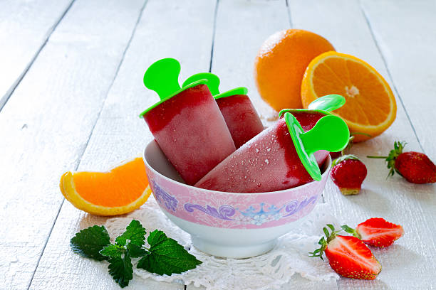 istock Strawberry ice cream popsicle orange on a white table 489485234