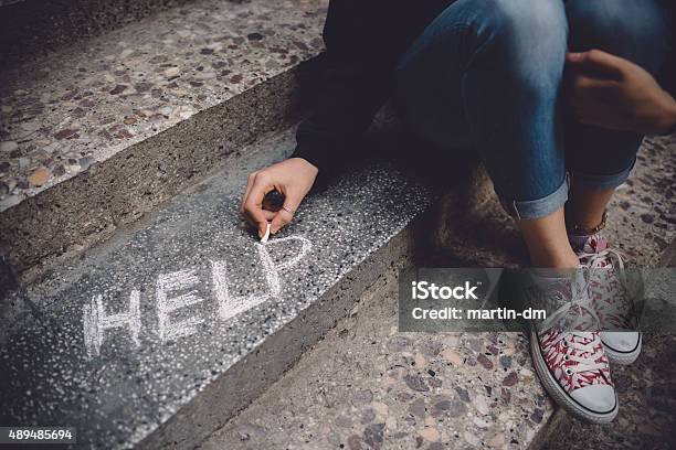 Unahppy Girl Writes Help On The Ground Stock Photo - Download Image Now - Depression - Sadness, Teenager, Despair