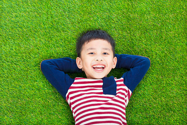 istock smiling kid lying and holding his head 489485743