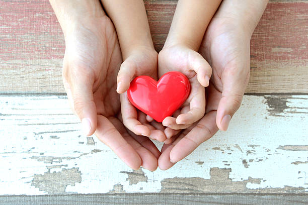 istock Red heart in child and mother's hands 489486004