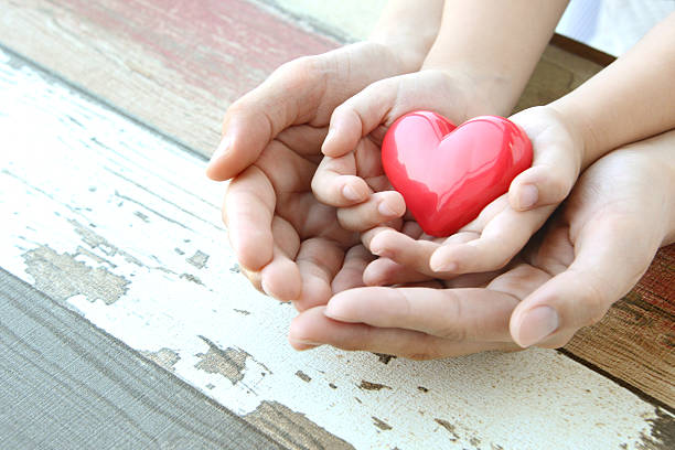 istock Red heart in child and mother's hands 489486064