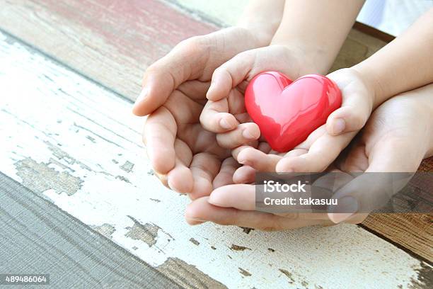 Red Heart In Child And Mothers Hands Stock Photo - Download Image Now - Donation Box, Blood Donation, Family