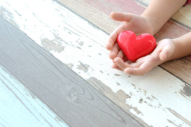 istock Red heart in child hands 489486126