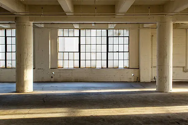 Clean and modern empty industrial warehouse interior in California without people. Cool urban feel of mid-century warehouse architecture that can be a place of work as well as an apartment loft. Large windows letting in light.