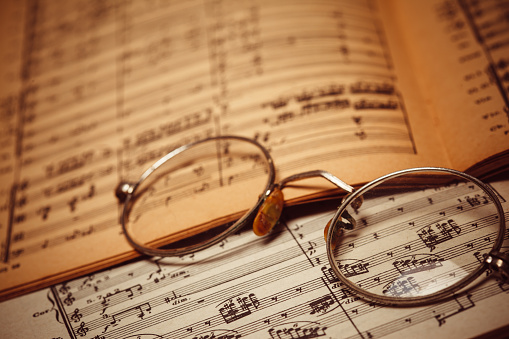 Glasses on a vintage sheet music from 19th century.