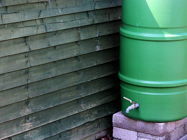 The two barrels are used to collect rainwater with the purpose to conserve water. The water can be used in the office buildings.