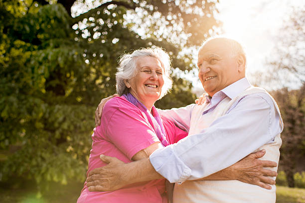 istock Smiling old couple embracing at the park. 489489338
