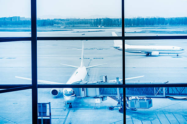 istock Parked aircraft on Beijing airport through the gate window 489490356