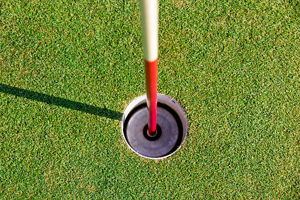 Golf hole and flag with the green grass