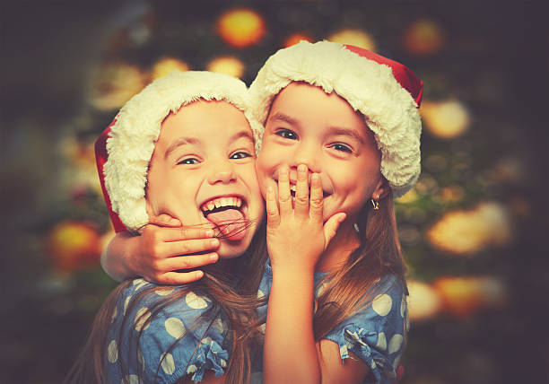 Christmas Happy funny children twins sisters Christmas Happy funny children twins sisters hugging twin photos stock pictures, royalty-free photos & images