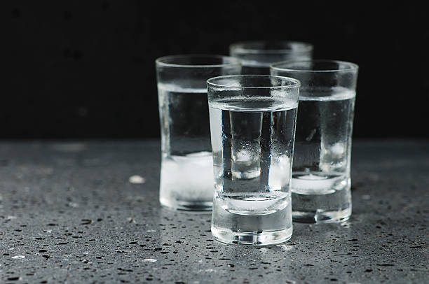 istock Glass of vodka on the black table 489492954