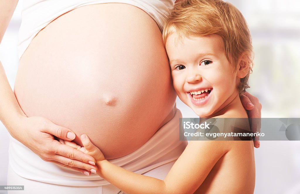 Happy family. Child hugs belly of pregnant mother A happy family. Child hugs belly of pregnant mother Human Abdomen Stock Photo