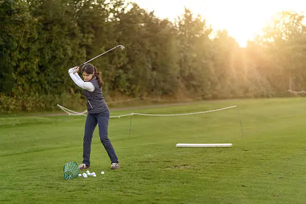 Photo of Female golfer practicing on a driving range