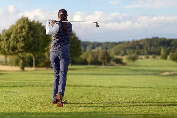 istock Female golfer striking the golf ball 489516616
