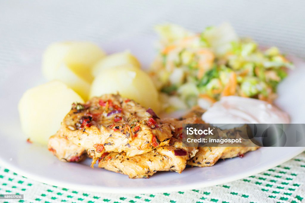 Roasted chicken chops, potato and salad Closeup of a chicken chips with Potatoes and Salad, focus on the meat. Salad with cabbage, apple and carrot. 2015 Stock Photo