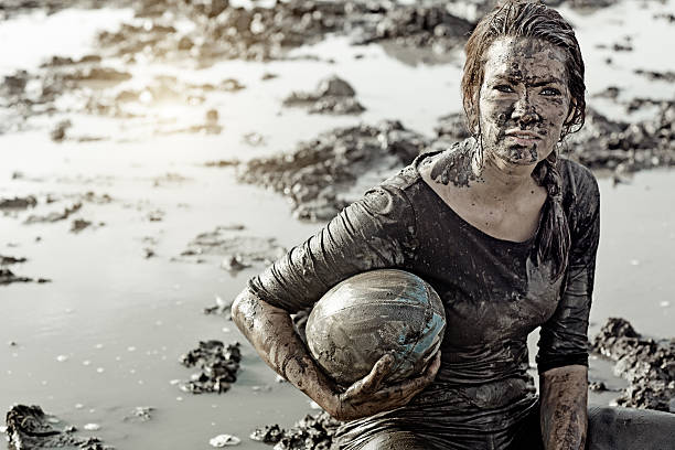 istock Young brunette female sitting during a mud run 489520902