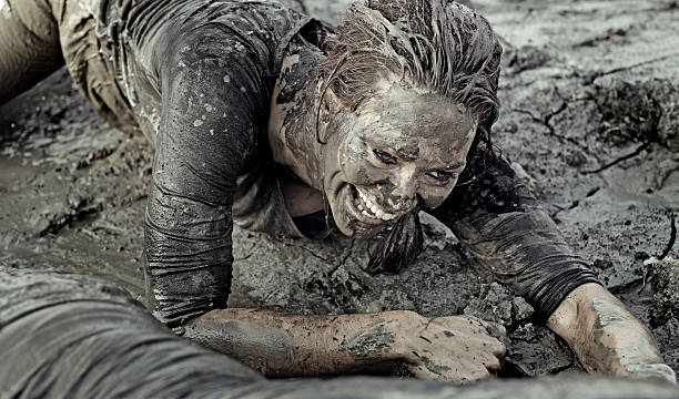 istock Young brunette female crawling during a mud run 489520984