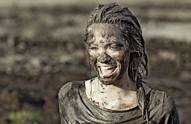 istock Young brunette female laughing during a mud run 489521178
