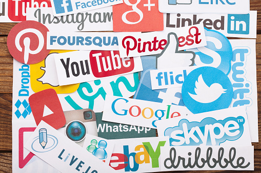 KIEV, UKRAINE - AUGUST 22, 2015:Collection of popular social media logos printed on paper:Facebook, Twitter, Google Plus, Instagram, Pinterest, Skype, YouTube, Linkedin and others on wooden background