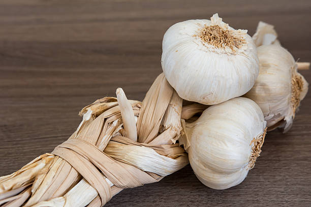 органические связка чеснока - garlic hanging string vegetable стоковые фото и изображения