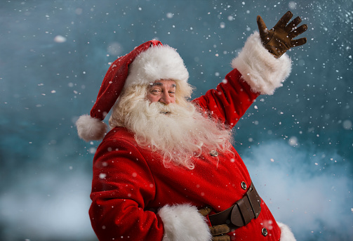 Happy Santa Claus laughing while standing outdoors at North Pole