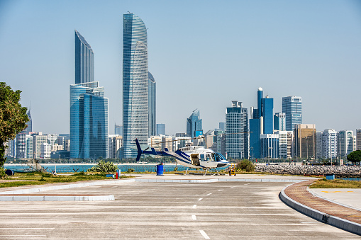 Helicopter on the aero track in Abu Dhabi, UAE. Skyscrapers in Corniche bay are in the background.