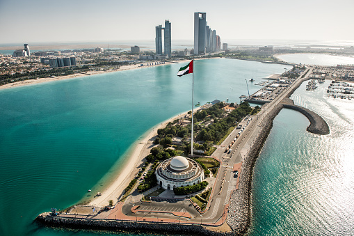 Helicopter point of view of Mosque in Abu Dhabi, UAE. Turquoise water and skyscrapers are also visible.