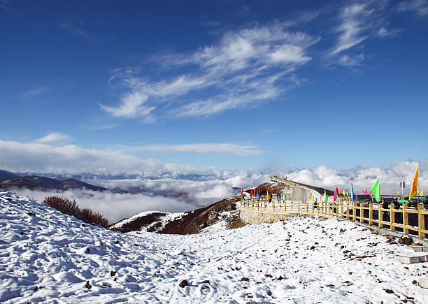 Sichuan, China - October 19, 2010: Tourists seeing snow mountain at view point from the peak of mountain range in Huanglong, Sichuan Province, China.