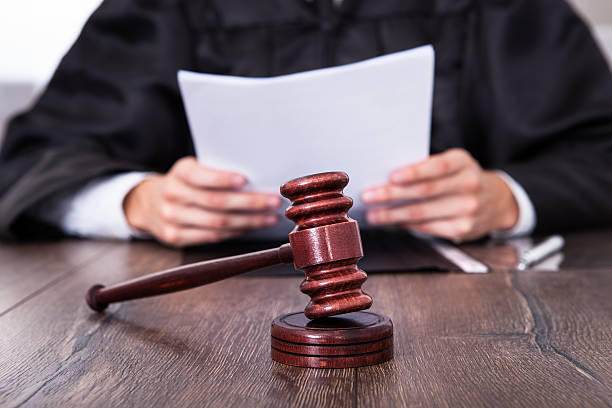 Judge Holding Documents Close-up Of Male Judge In Front Of Mallet Holding Documents courthouse stock pictures, royalty-free photos & images