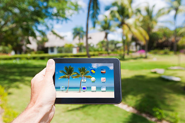 tiene un tablet pc in un paradiso tropicale - digital tablet beach digital display pc foto e immagini stock