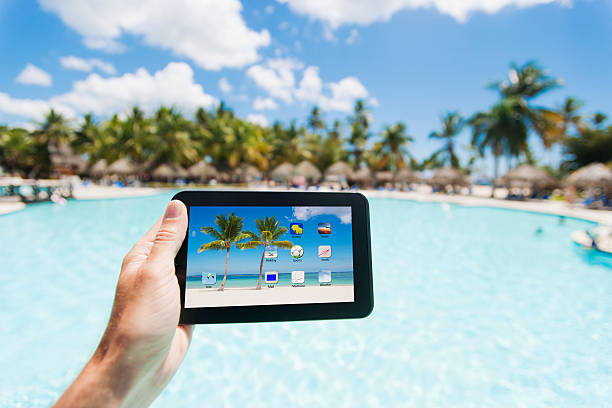 tiene un tablet pc in un paradiso tropicale - digital tablet beach digital display pc foto e immagini stock