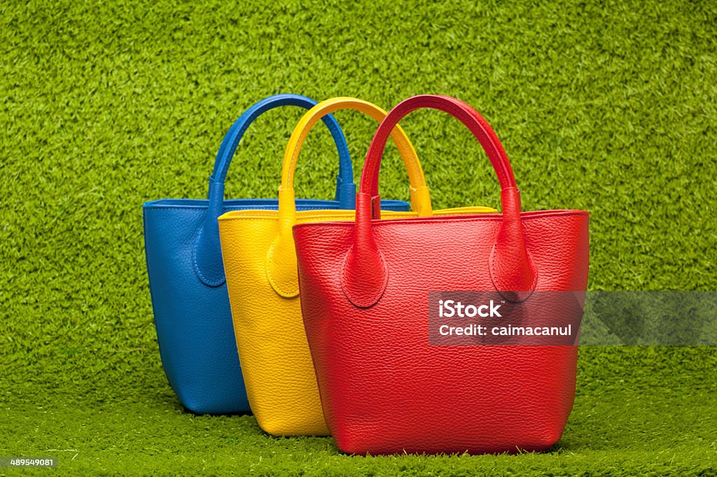 purses on green grass red, yellow and blue purses on green grass Adult Stock Photo