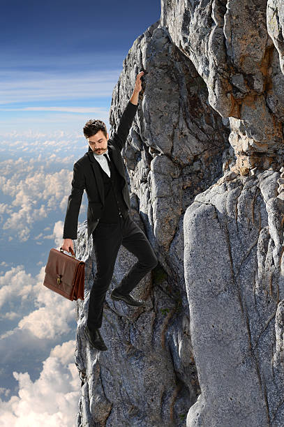 istock Businessman Clinging Onto Rock 489555268