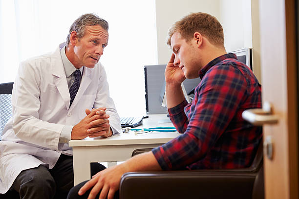 Doctor Treating Male Patient Suffering With Depression Doctor Treating Male Patient Suffering With Depression two-white-doors stock pictures, royalty-free photos & images