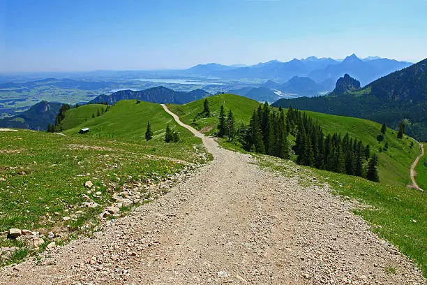Gravel trail to the peak of mountain Breitenberg (heights 1893 m) in the Bavarian Alps. Due to the very good weather conditions, even the Forggensee can be seen far in the background.