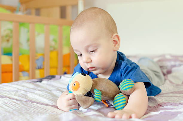 istock baby boy playing with soft toy on the bed 489558904