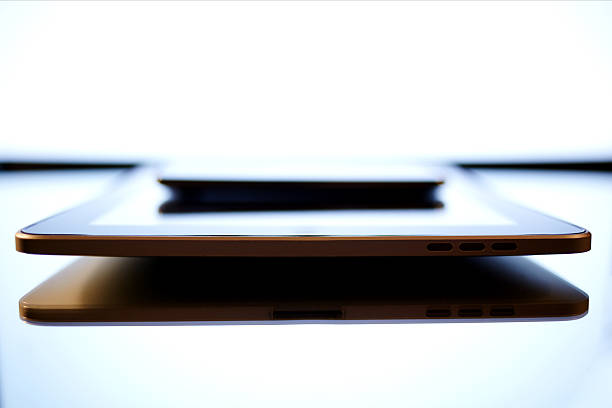 Close up shot with smart phone above digital tablet lying on glass modern desk or table with beautiful screen reflection, modern device product, big copy space for your text message