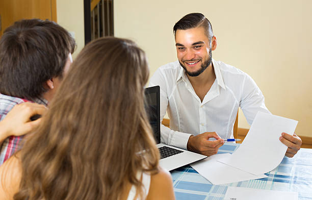 istock Salesman and young couple at home 489560502