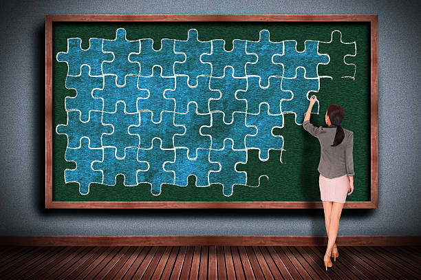istock Woman Drawing Puzzle Pieces with Chalk on Chalkboard 489560674