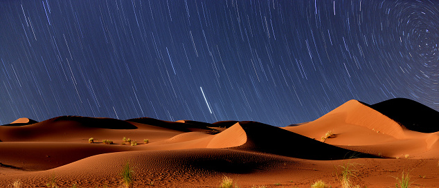 Saharan dunes at Erg Chigaga, Morocco, near Algerian border. Exact location: N29 51.440 W6 14.572. Long exposition (35 minutes), wide angle picture taken at night shows beautiful star trails. Stars appear rotating around the North Star (upper right corner) during long time night sky exposure.