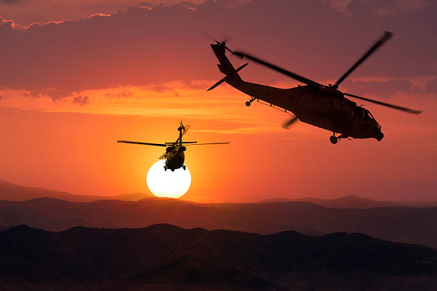 istock Two flying army helicopters on sunset background 489566112
