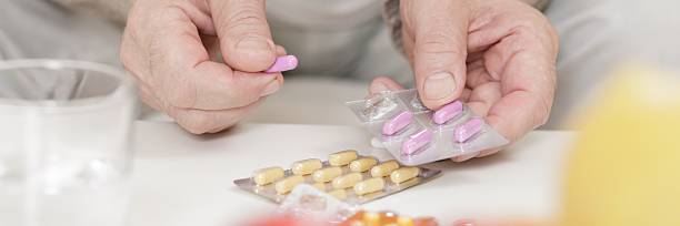 istock Ill person taking pink pills 489567262